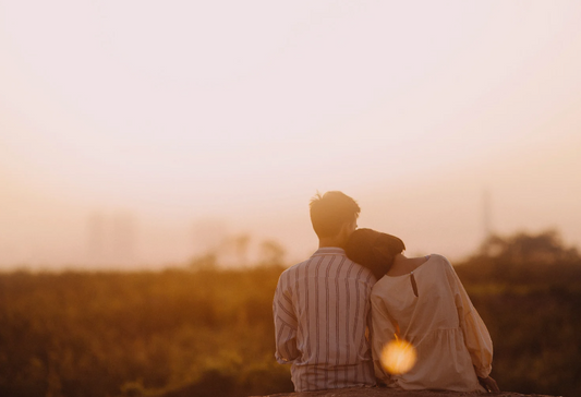 dating for stroke survivors: a couple cuddling together romantically as they watch the horizon while the sun sets