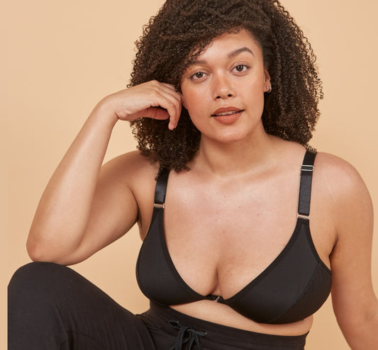 Beautiful young woman with a sultry look straight at camera wearing a black adaptive bra designed as a bra for disabled women
