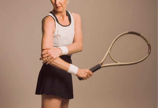 Will tennis elbow go away? Older fit woman with a tennis racket holding onto her elbow