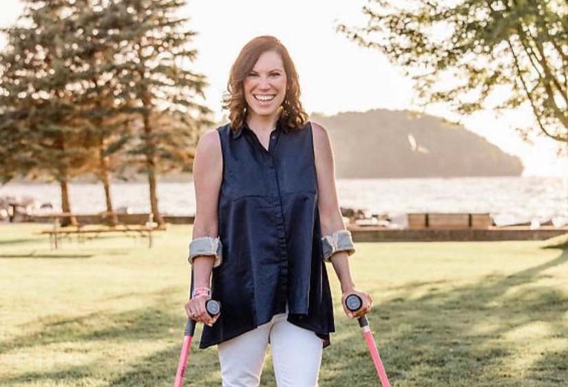 Molly Farrell in a beautiful blue top with white pants, smiling and shinning at golden hour