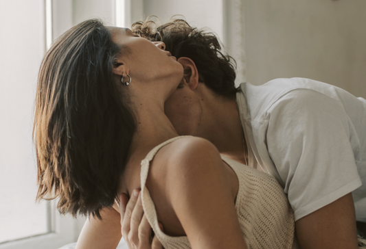 How to have sex again: a sensual image of a couple where the man is holding the woman's back and kissing her neck