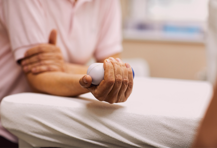 Tips for physical therapy: a person holding a weight in one hand, while touching that arm with the other hand