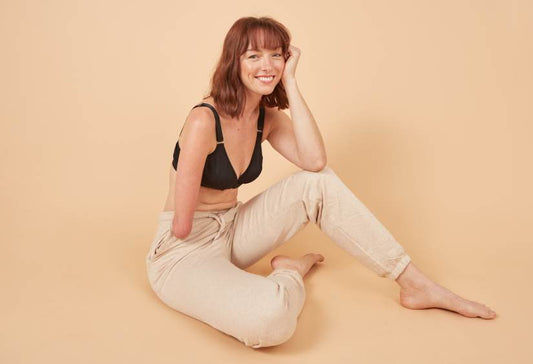 Who Can An Adaptive Bra Help: young woman with a limb difference posing and smiling in her adaptive bra