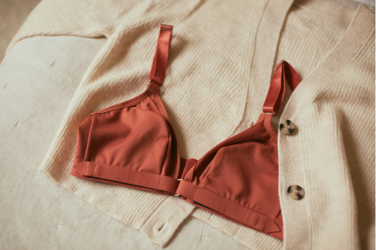 Springrose limited mobility bra in terracotta laying on top of a beige cardigan