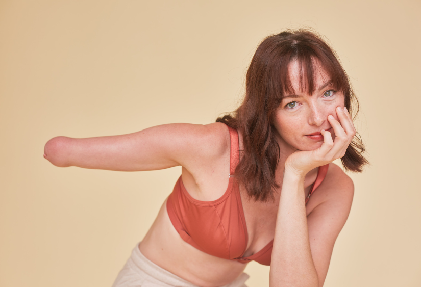 How to put on a bra with one hand - A beautiful young woman with only one hand is staring confidently at the camera while wearing the Springrose one handed bra