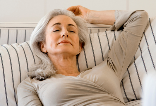How to take care of your wife after surgery: a white, silver-haired woman reclining on a couch