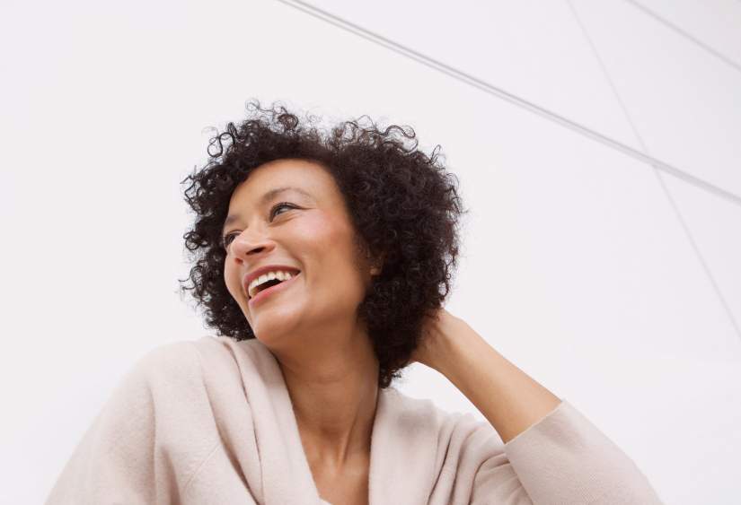Shoulder surgery recovery tips: beautiful woman smiling off into the distance with her hand in her hair
