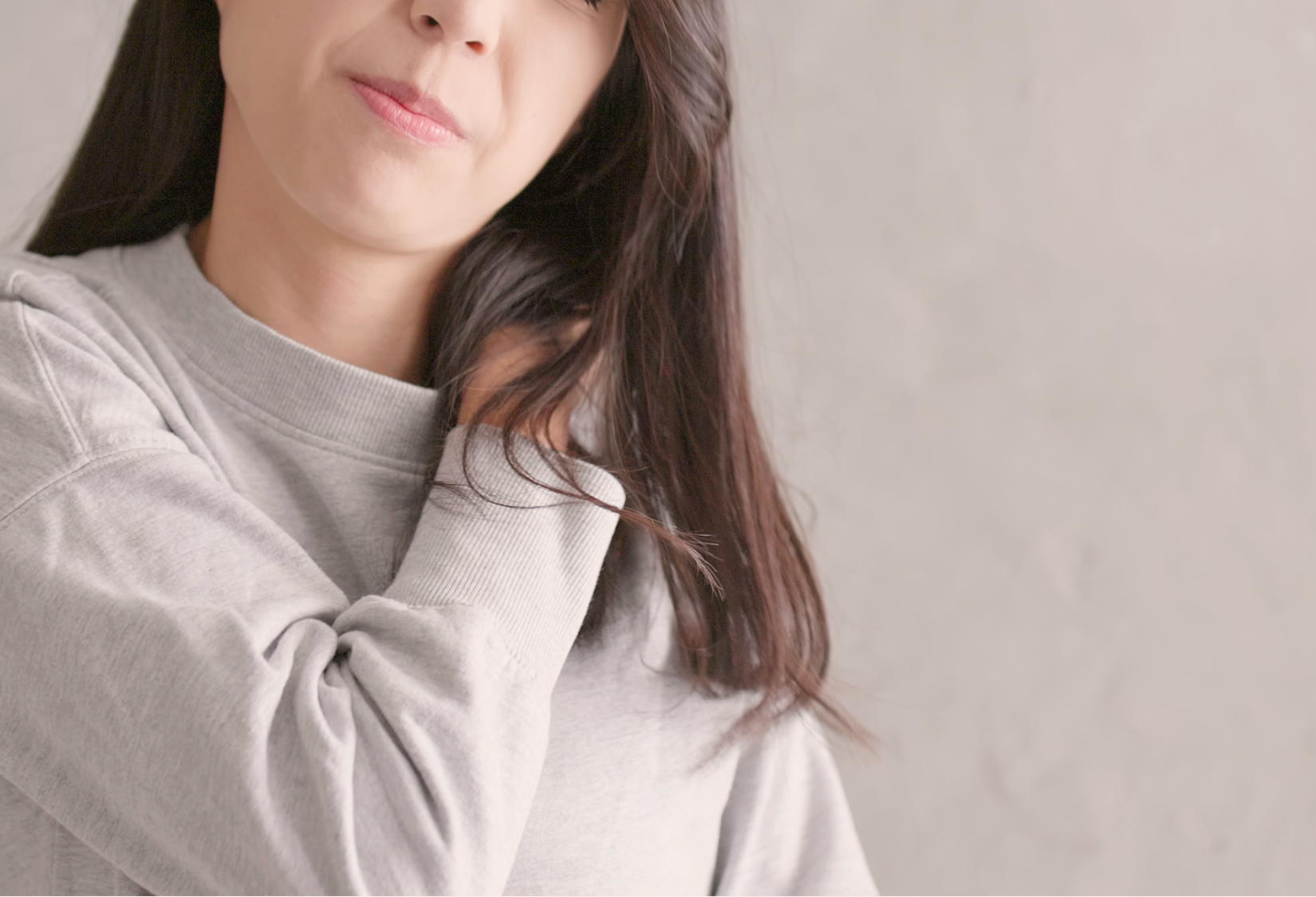 tips for rotator cuff surgery: woman holds her shoulder in discomfort