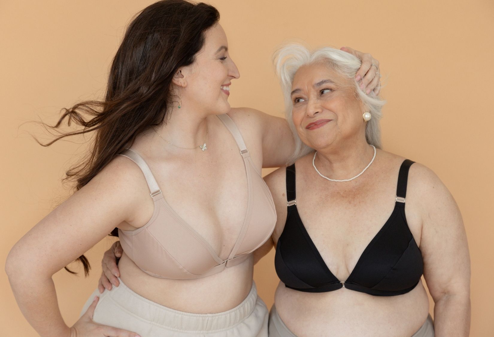 Two women, one a senior, side hugging while wearing Springrose's adaptive bras for senior women