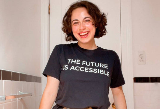 Britt, a pretty happy-looking young woman, smiling widely and wearing a "the future is accessible" shirt