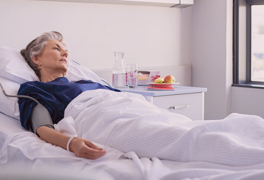 What to expect after a stroke: Woman lying in a hospital bed looking pensively out the window