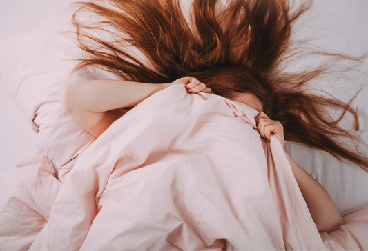 Fatigue, Pain, and Sex - ME/CFS and Fibromyalgia: red-headed woman hiding under pink bedsheets