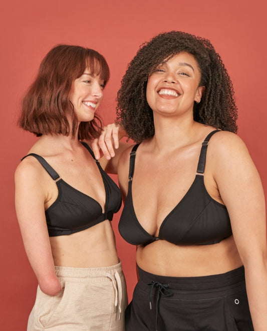 Two happy looking women wearing black, velcro adaptive bras