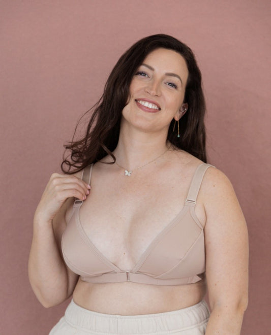 A beautiful young woman smiling at the camera while wearing the Springrose easy-on adaptive bra in beige
