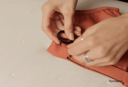 Woman demonstrates how to put on the Springrose adaptive bra overhead
