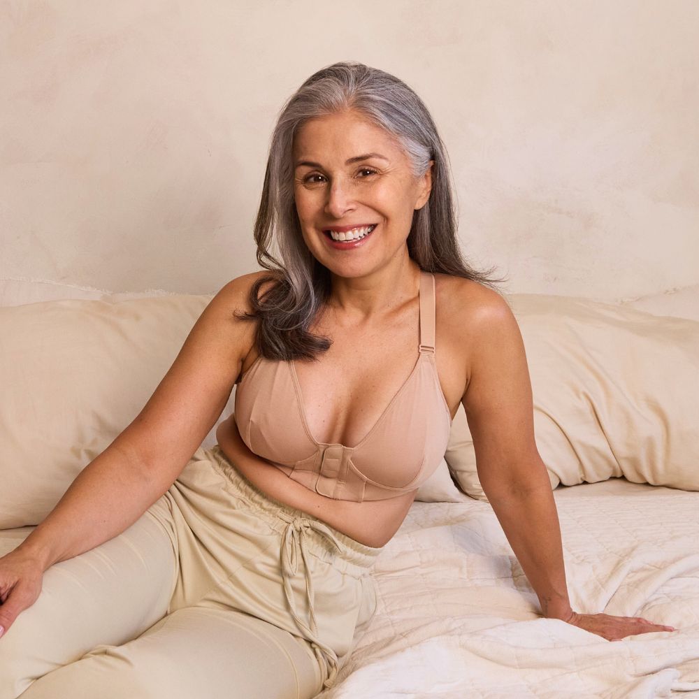Beautiful mature model wearing a magnetic bra while lounging in bed
