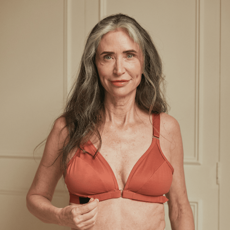 Beautiful older woman showcasing the bra for elderly with arthritis in terracotta
