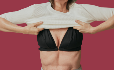 Mature woman pulling down a white sweater over the front closing bras for seniors designed to be a bra for arthritis