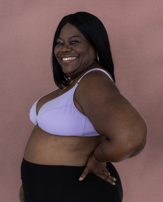 Beautiful mature black model showing off the Springrose adaptive bra in lilac with a smile and flare