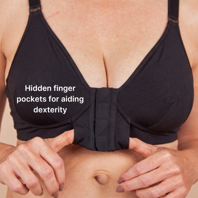 Close up of the magnet bra with thumbs in the hidden finger pockets. Text reads: hidden finger pockets for aiding dexterity.
