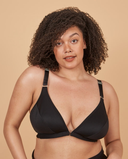 Young woman in a black wireless front closure bra looking at the camera with a sultry expression