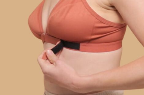 Close up of the easiest bra to wear after shoulder surgery because of the velcro front closure, highlighted by the woman in the image