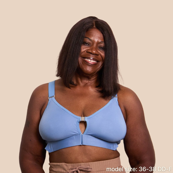 Front view of the Springrose velcro bra in Neptune Blue. The beautiful model is smiling at the camera. Text reads: model size is 36-38 DD-F.