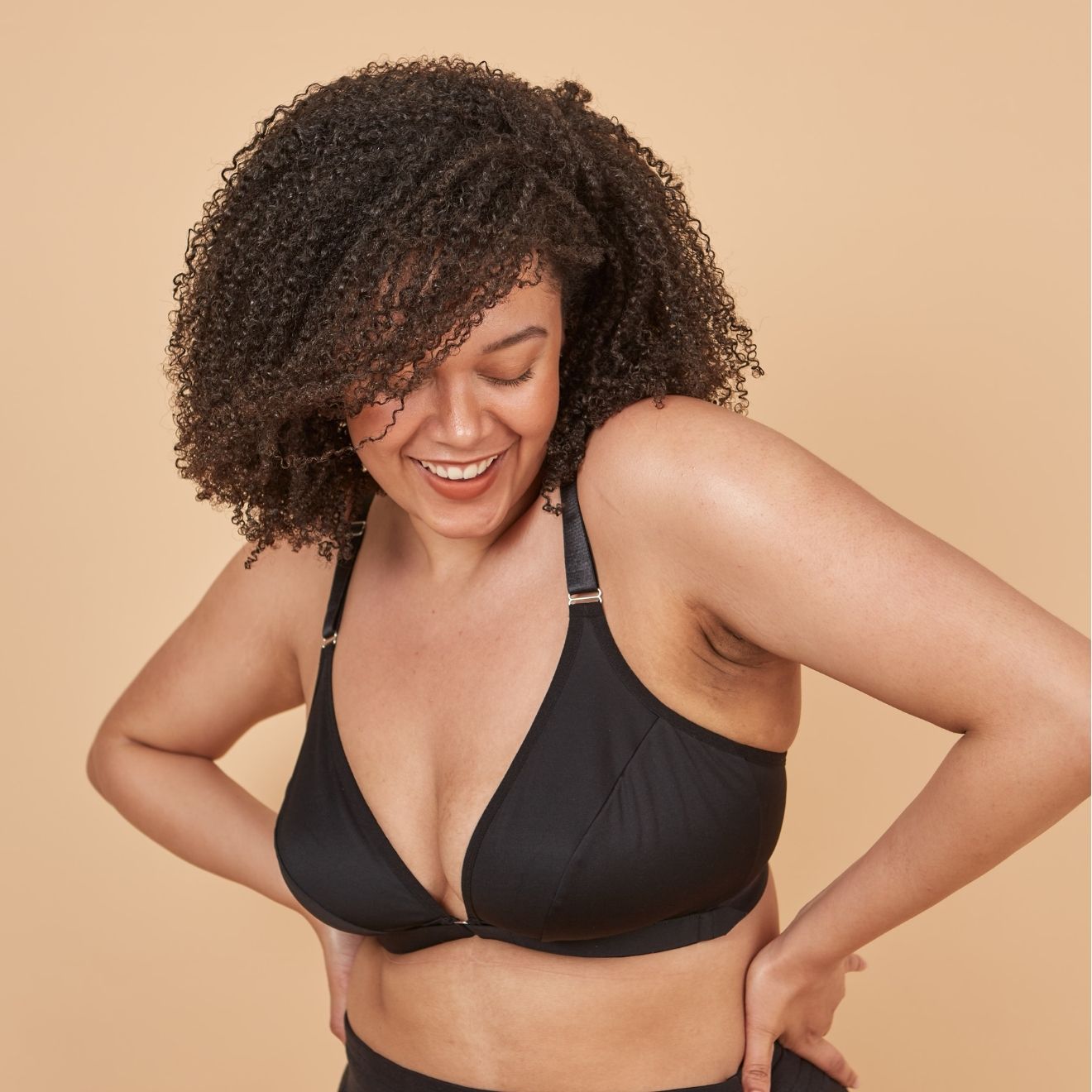 Beautiful model wearing the Springrose scoliosis bra, shrugging her shoulders and laughing