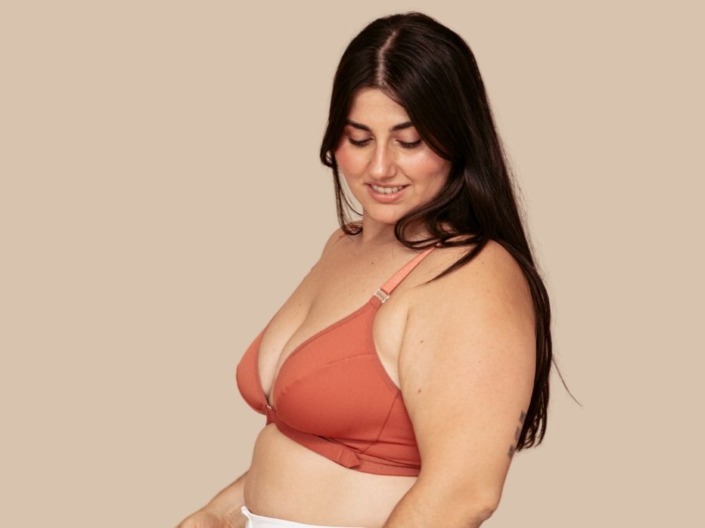 Beautiful young model wearing the Springrose adaptive bra in terracotta while looking down