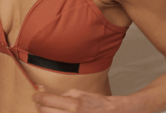Close up GIF of a woman closing the front closure adaptive bra one handed