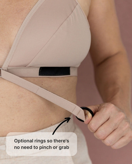A close up of the Springrose adaptive bra's velcro closure and optional rings. Text reads: optional rings so there's no need to pinch or grab.